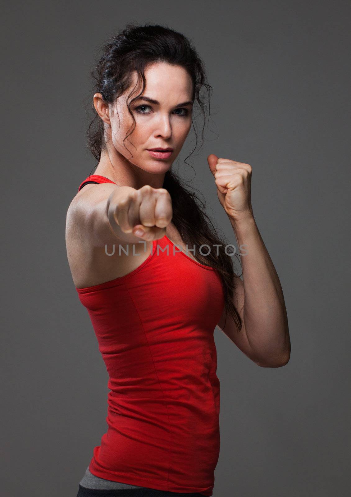 An attractive sexy woman throwing a punch during boxing exercise