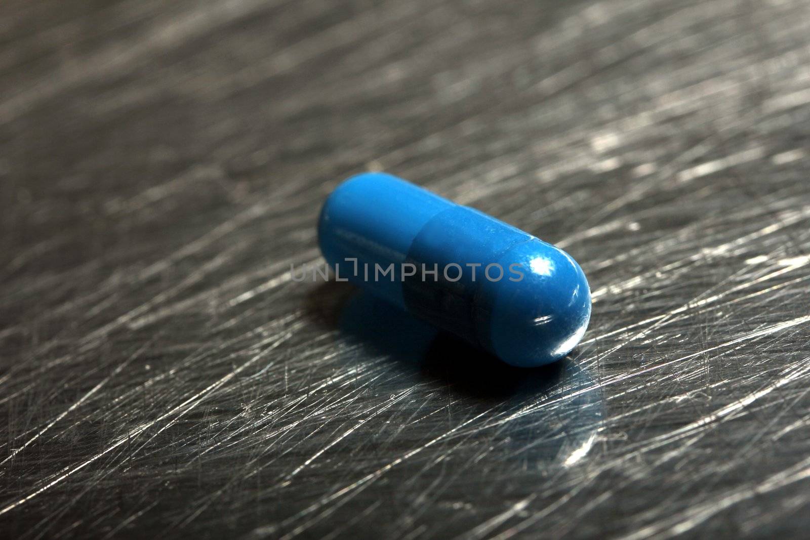colored medicinical capsule on a steel plate