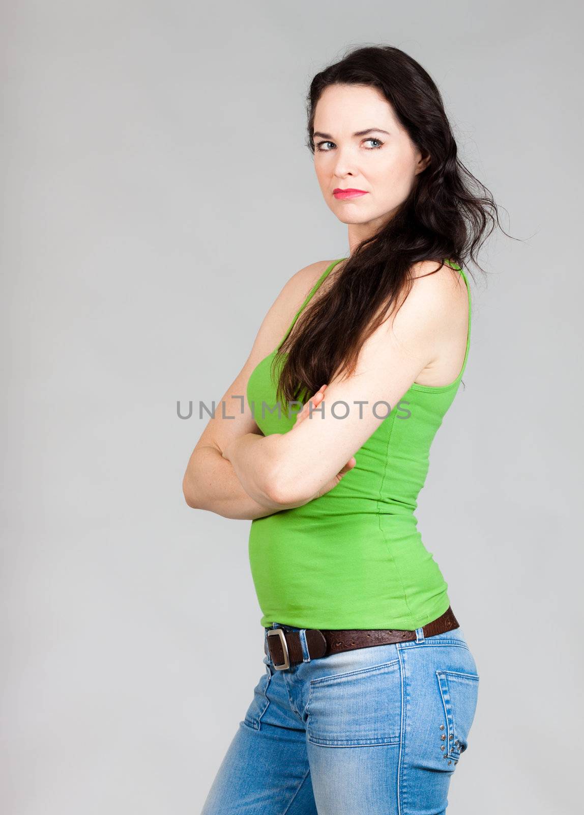 A jealous beautiful woman looking away. Over grey background