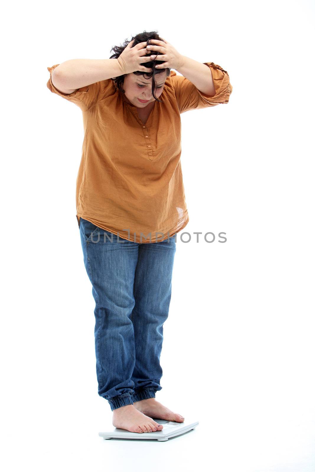 Women with overweight standing on a scale and is shocked - cutout on white
