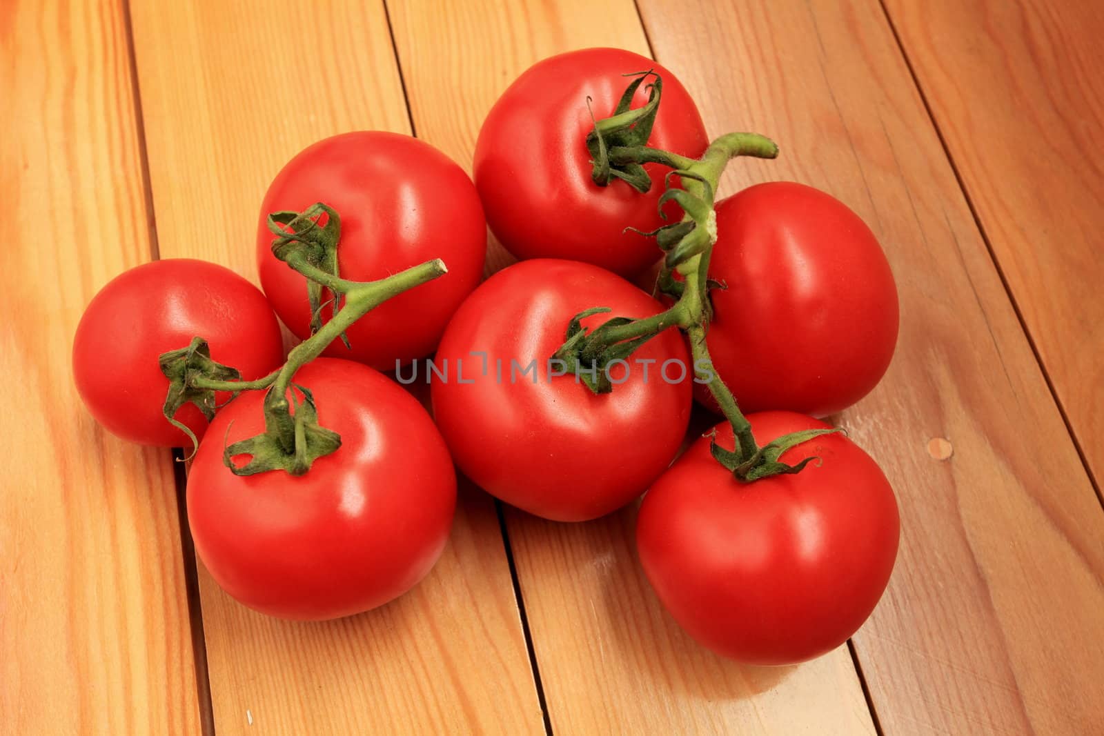 red tomatoes on the branches lie on the table