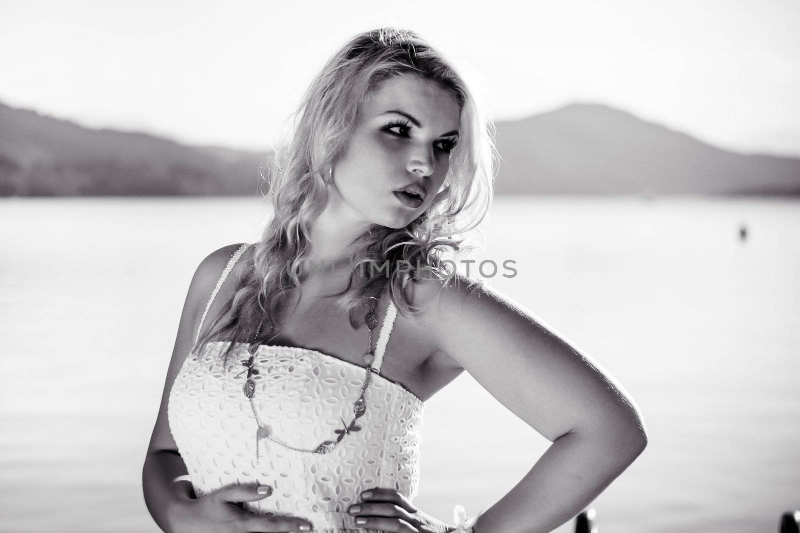Black & White Photo of a Model standing in front of a lake by dwaschnig_photo