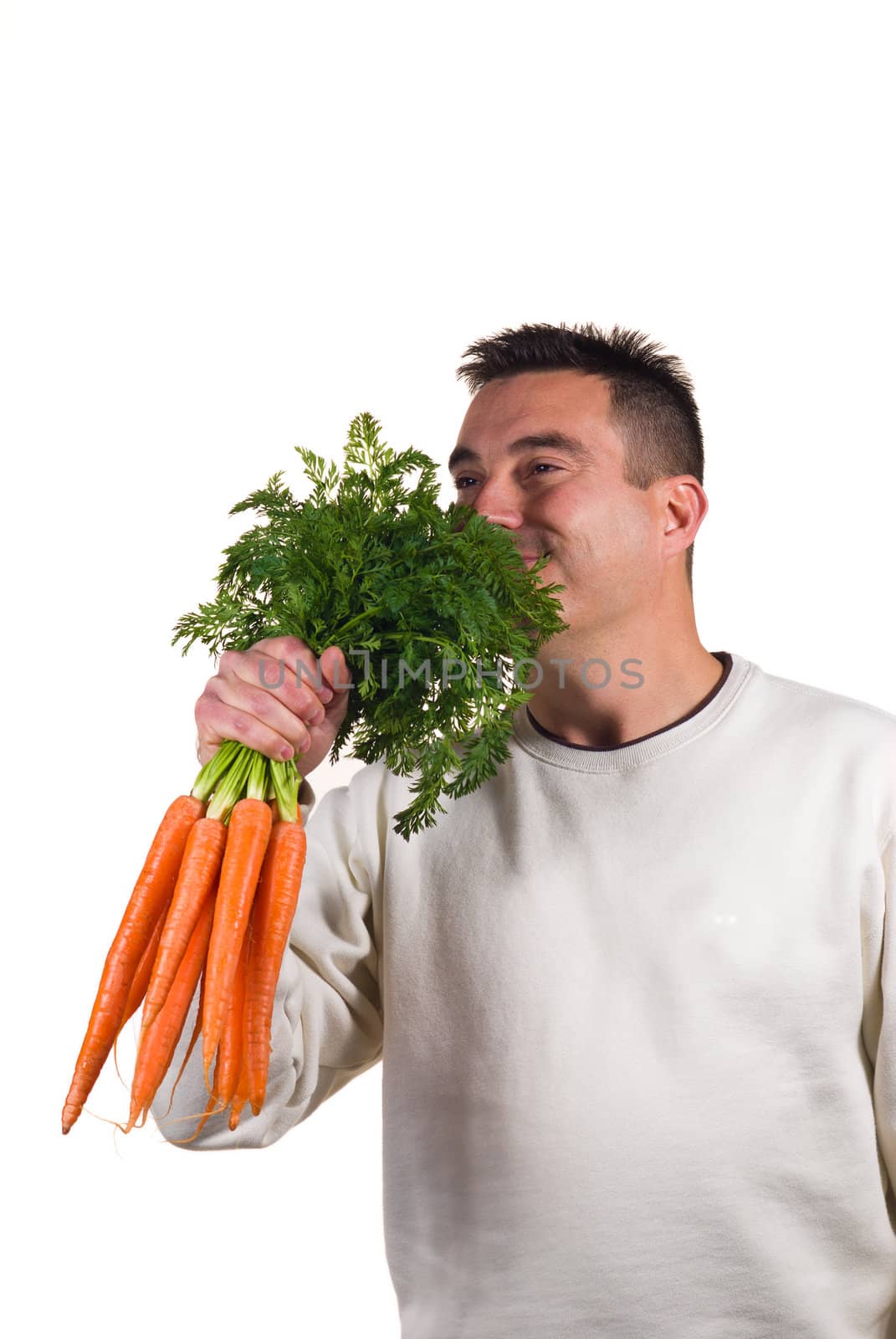 Guy happily holding a bunch of carrots, dieting concept