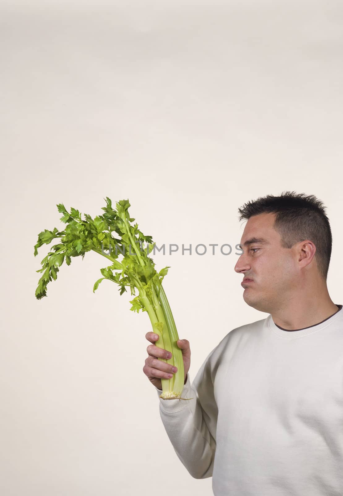 Guy holding a bunch of celery, diet frustation concept