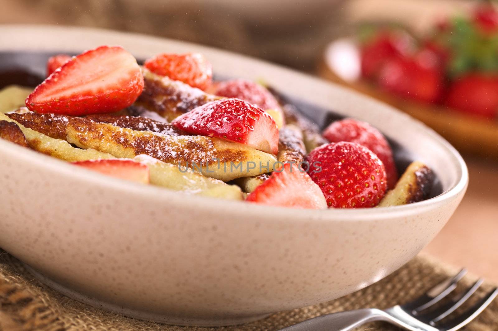 Schupfnudeln (Swabian potato noodles from Southern Germany) with fresh strawberries, cinnamon and sugar powder (Selective Focus, Focus on the front of the strawberry in the middle of the image and the noodle below it) 