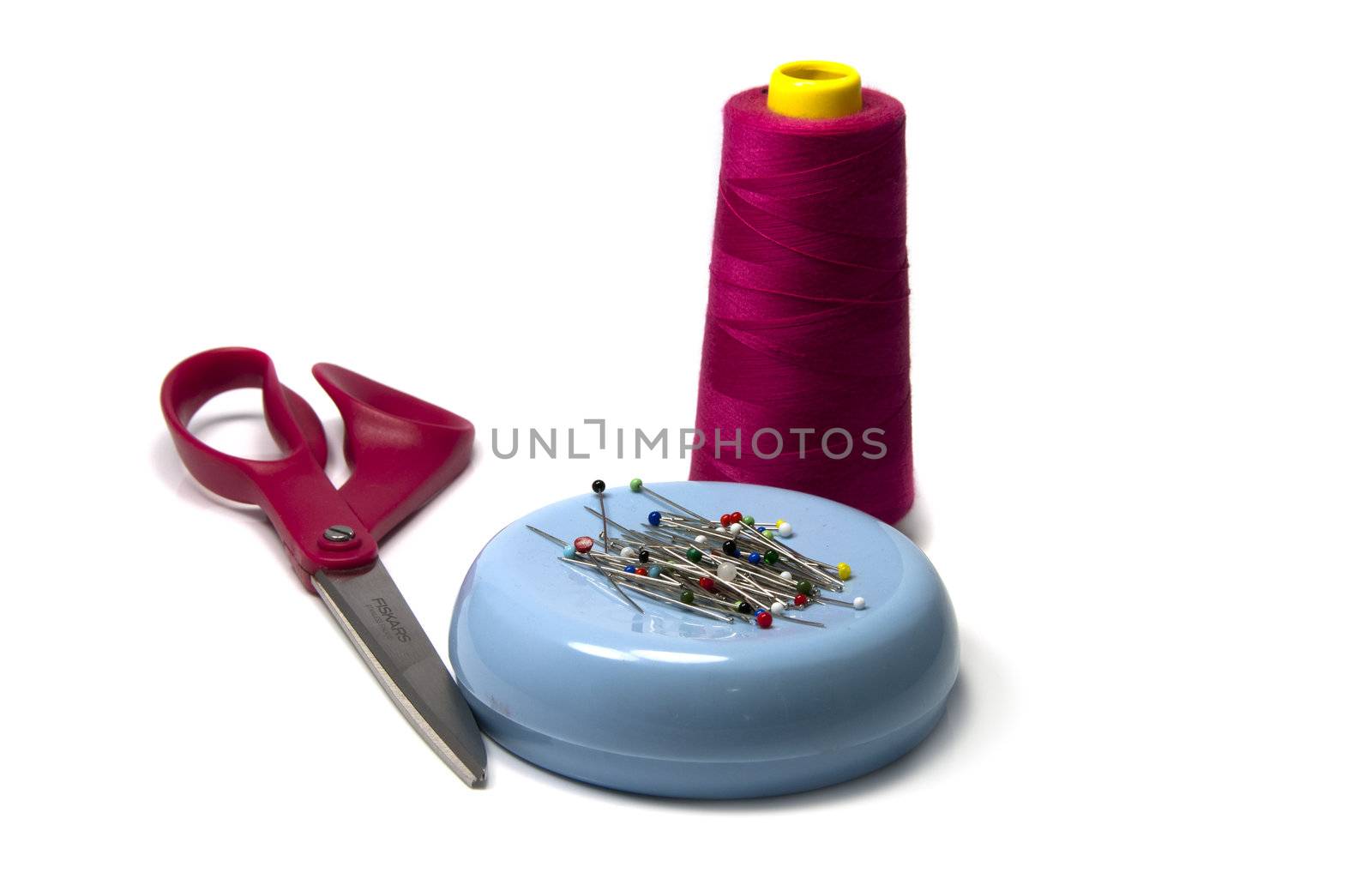 sewing material with siccors and needles and pink cotton