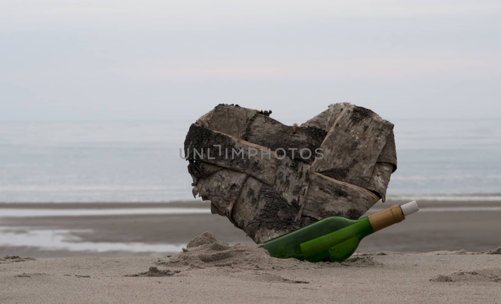 green bottle post and a lost heart on the beach
