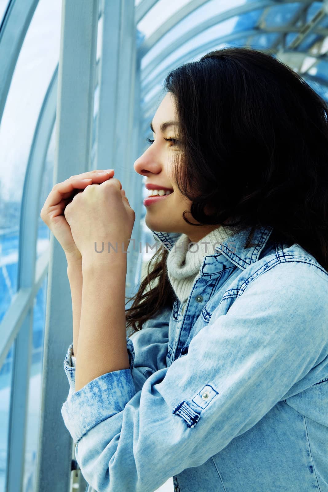 attractive girl in a denim jacket in a modern building against windows by Serp