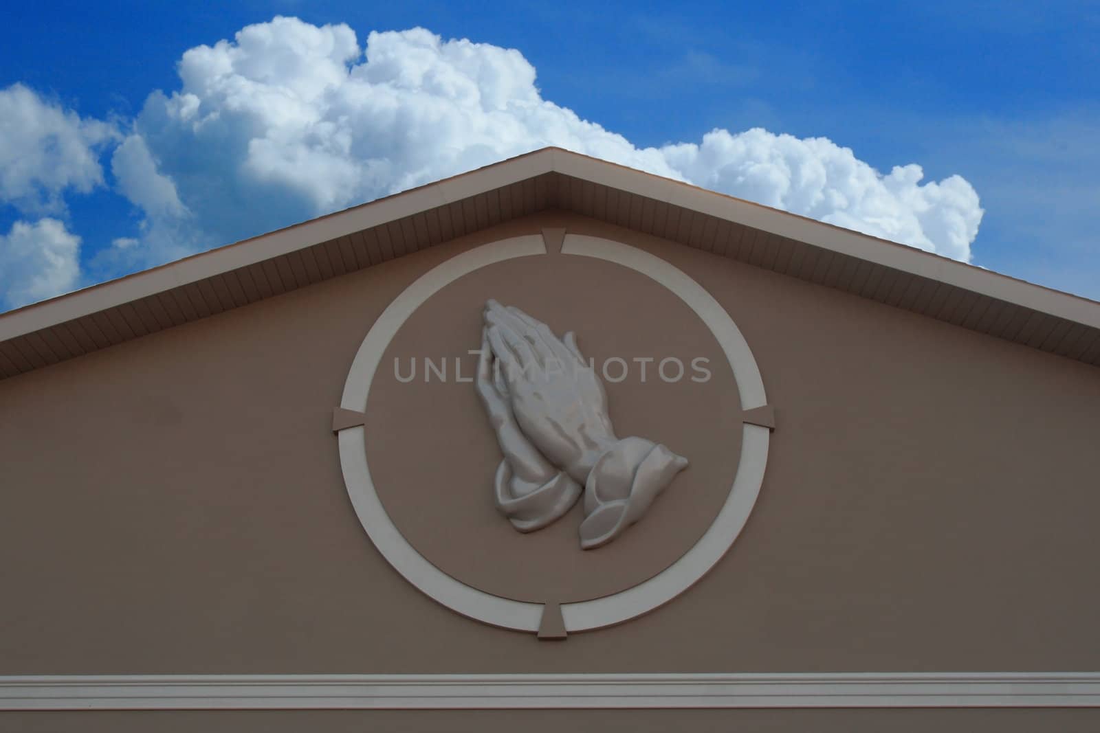 prayer hands against blue sky