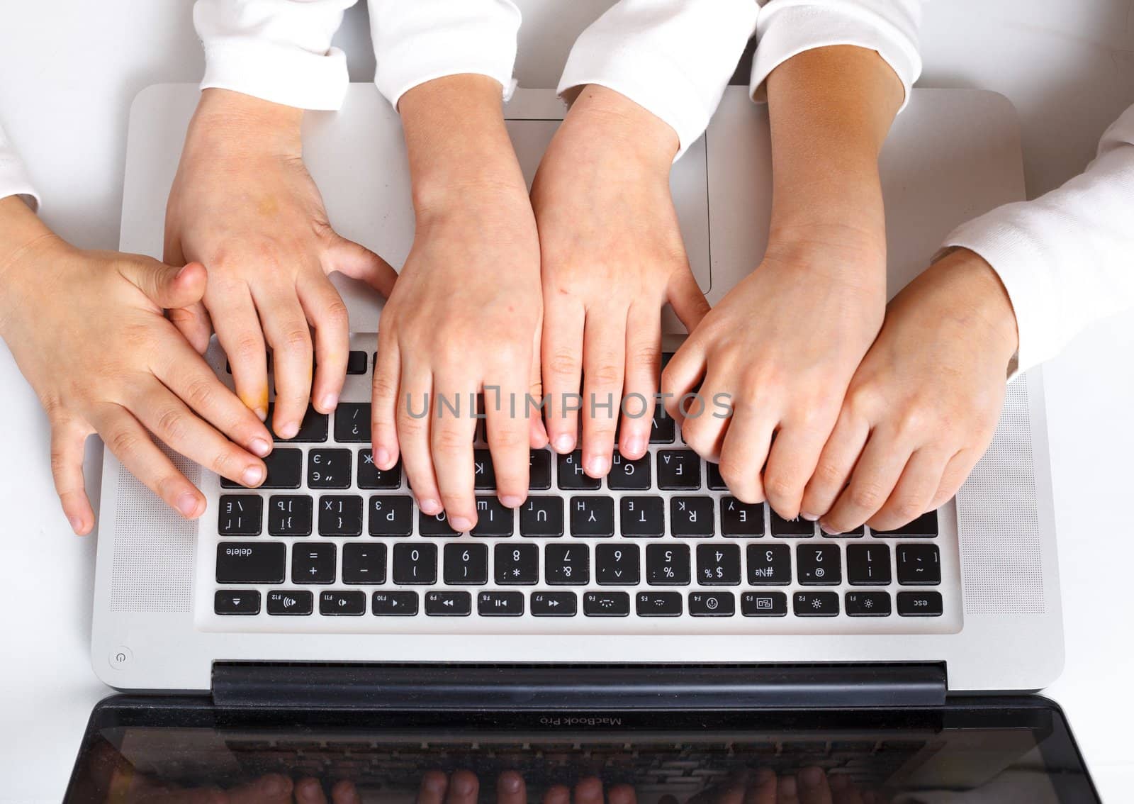 Kids hands on keypad of laptop at workplace