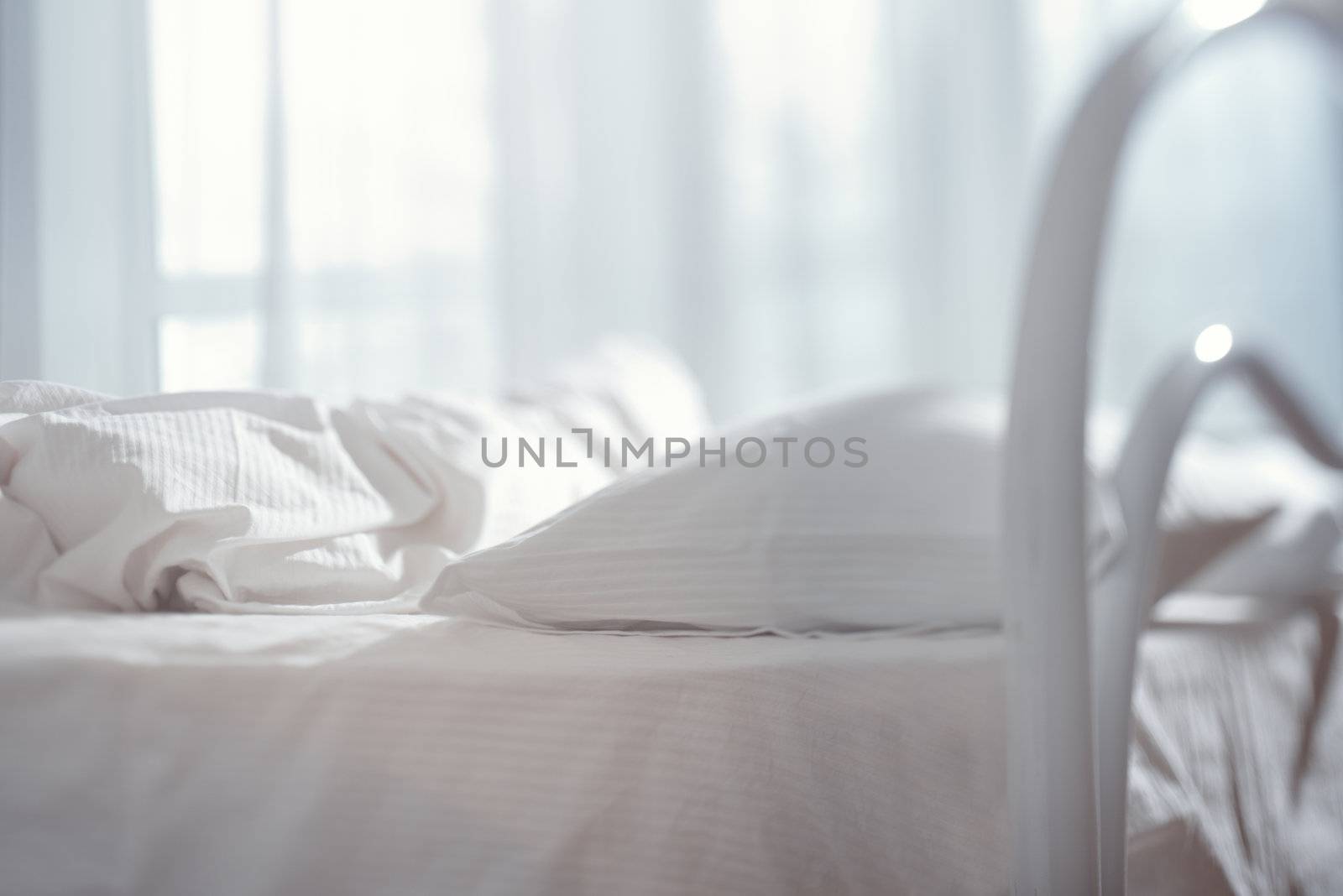 Bedroom with bed and linen. Natural light