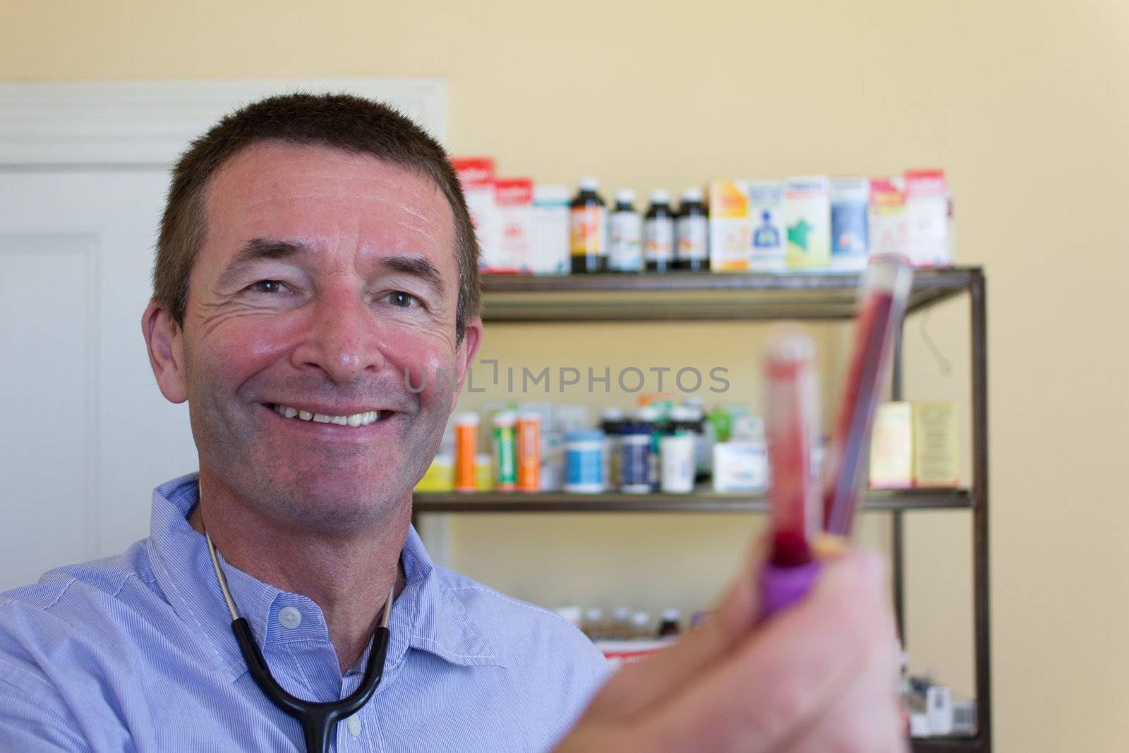 Mature Doctor Showing Blood Capsules by dwaschnig_photo
