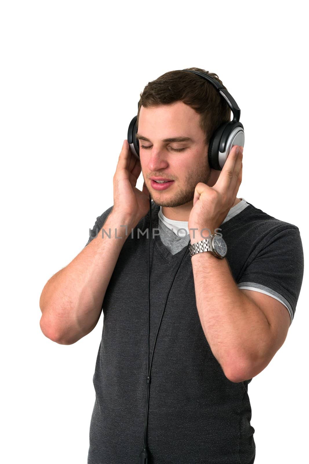 Young man in grey t-shirt listening to music with earphones