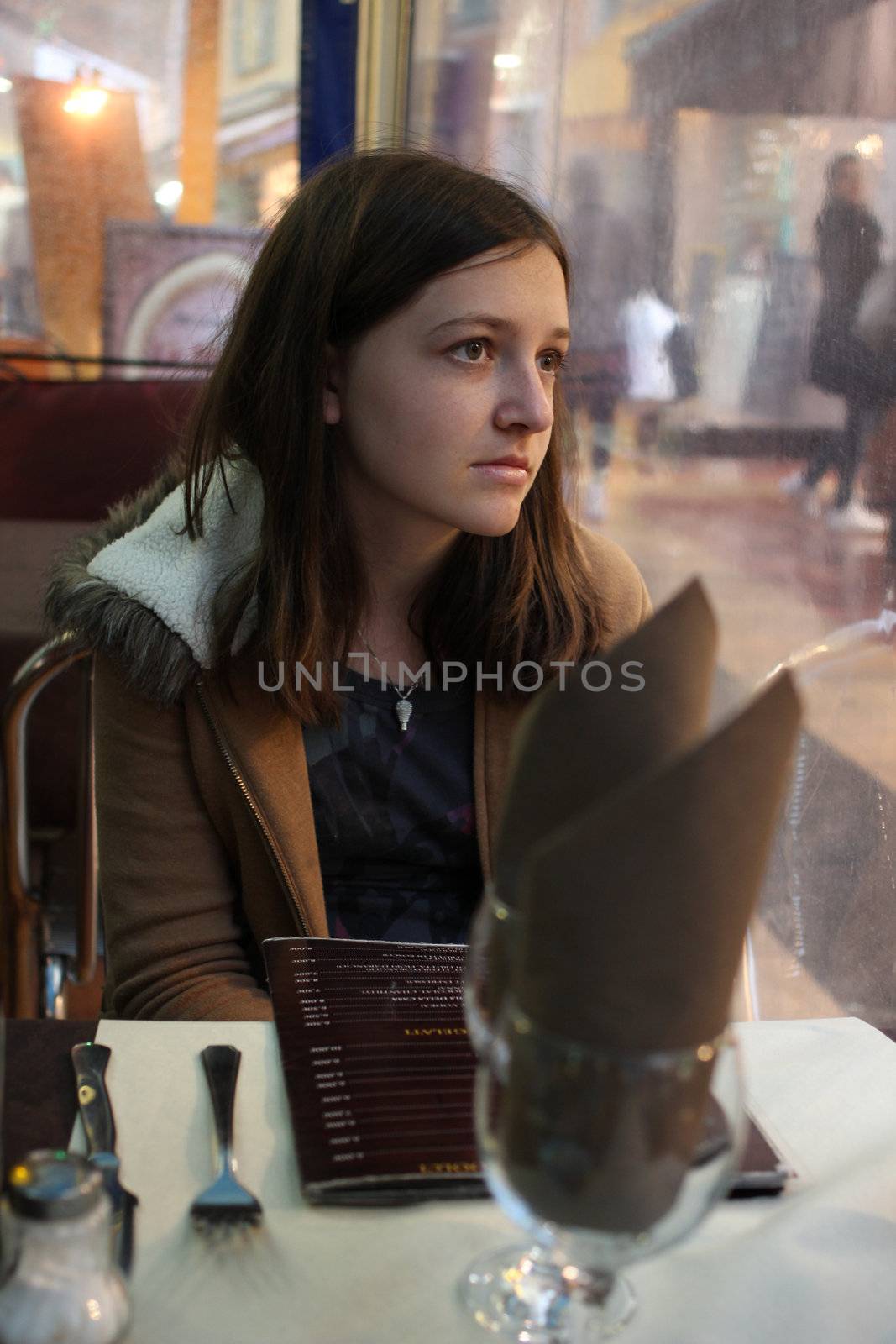 Young Brunette Girl Sitting at a restaurant by dwaschnig_photo