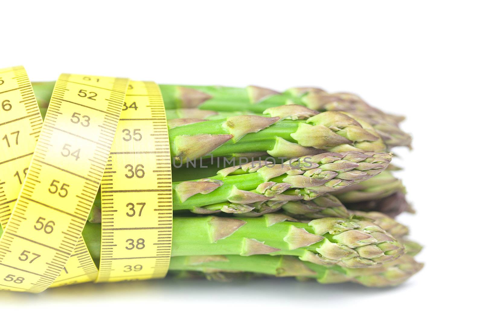 bunch of asparagus tied with measuring tape isolated on white by jannyjus