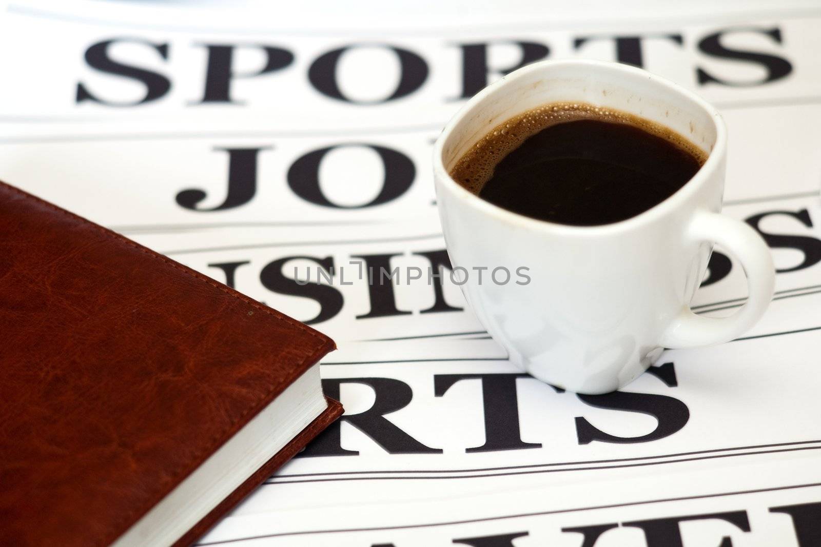 An image of a cup of coffee and a newspaper