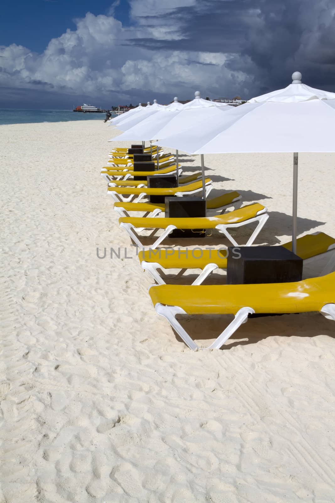 Rows of several lounge chairs and umbrellas on the beach