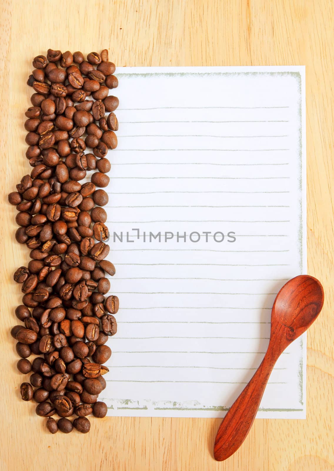 Coffee beans and spoon with paper for notes on the wooden backgr by nuchylee