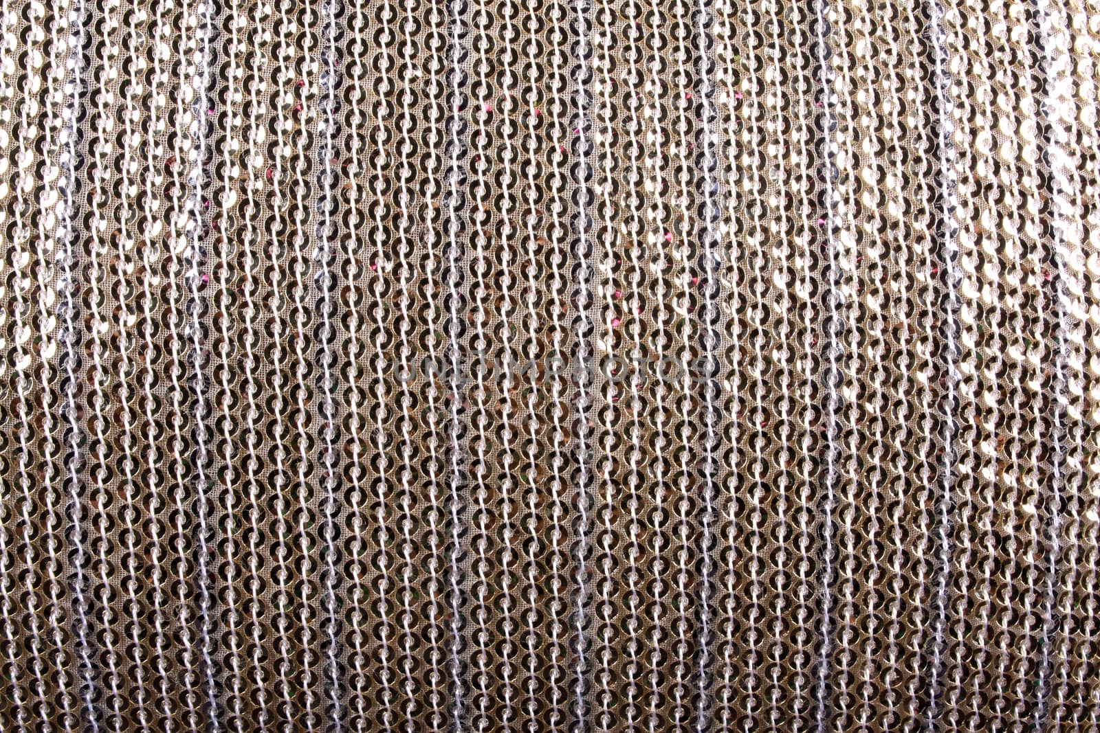 A background of a white cloth with a pattern of woven sequins.