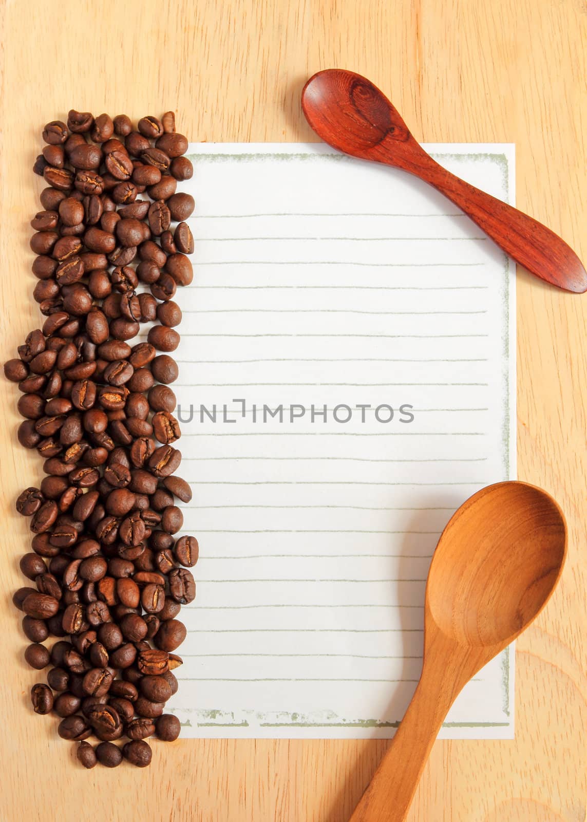 Coffee beans and spoon with paper for notes on the wooden backgr by nuchylee
