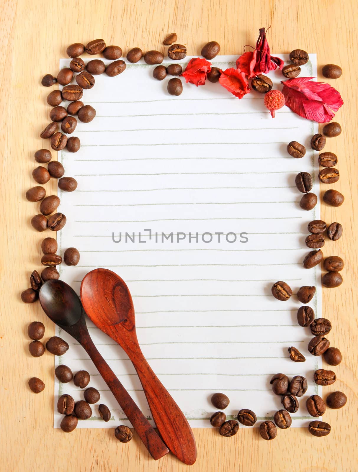 Coffee beans and spoon with paper for notes on the wooden background