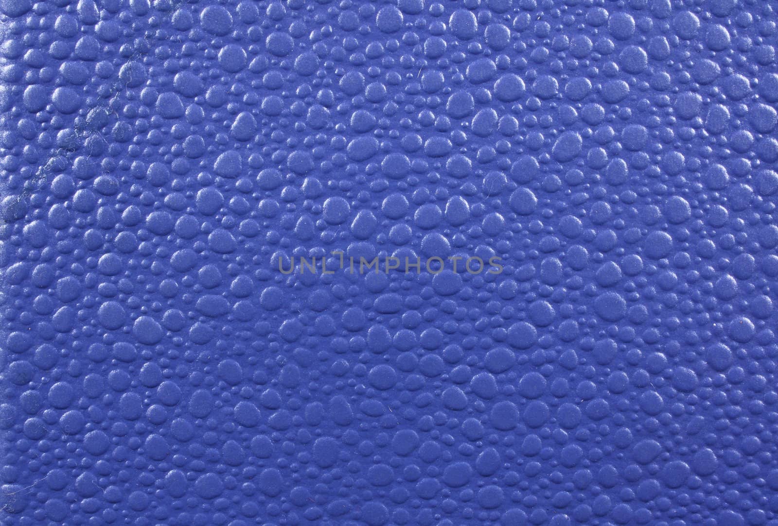 A background of a blue leather with abstract design on it.