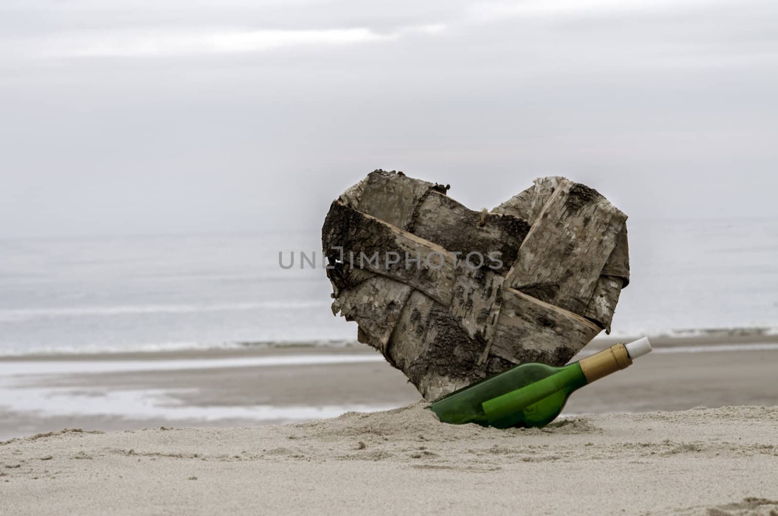 green bottle post and a lost heart on the beach