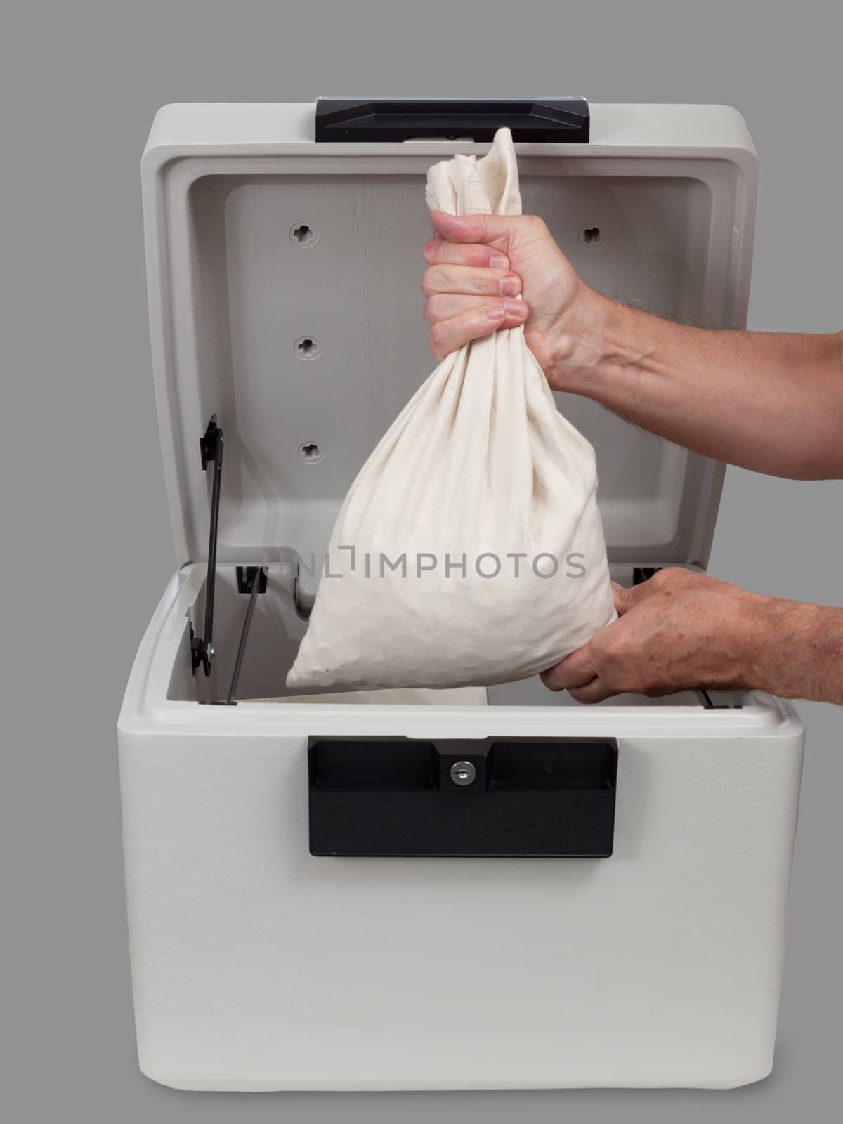 Fire proof safe open and large cotton cash bag being placed inside