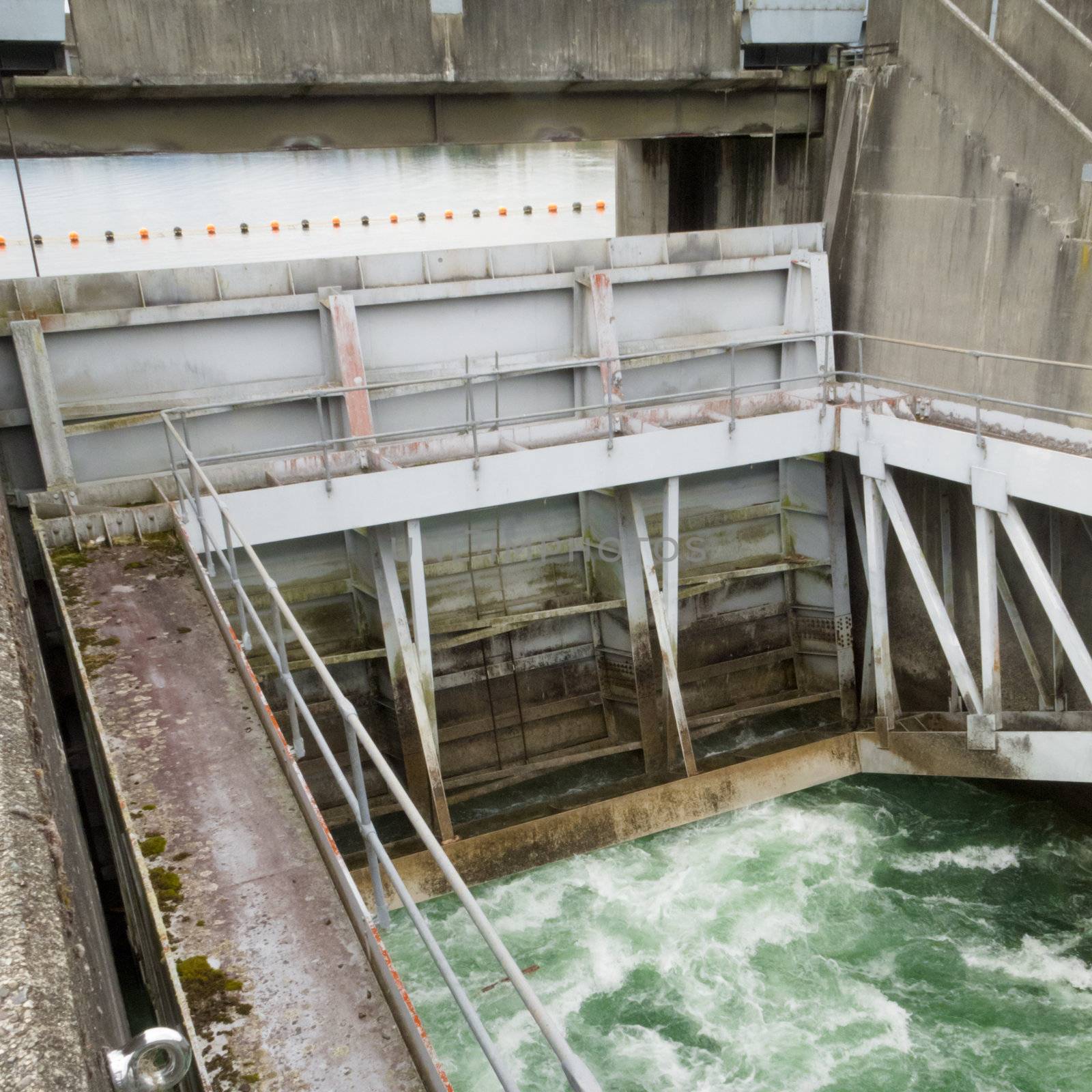 Hydro control structure weir with flow passing underneath causing a violent turbulence discharge of white water