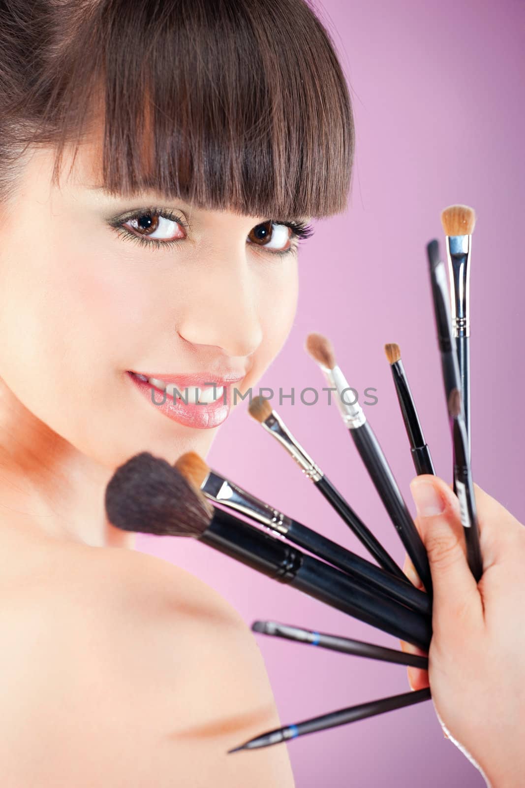 Pretty woman holding set of make up brushes