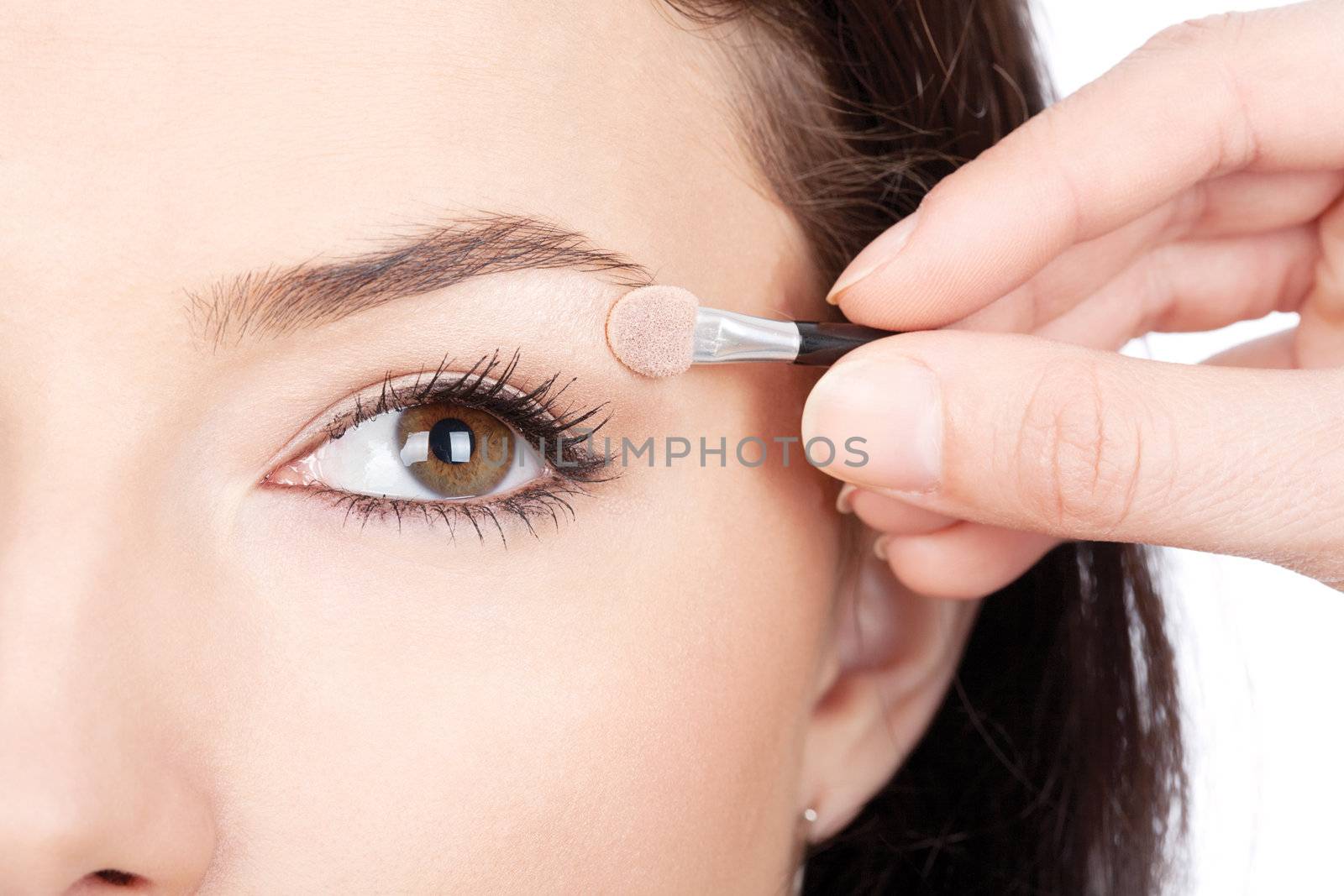 Close up look of applying eyeshadow with applicator, isolated on white background