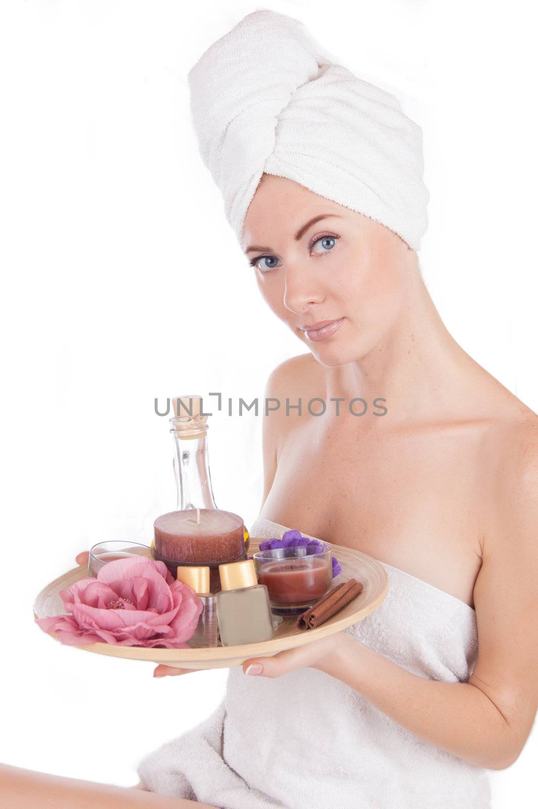 Sensual woman with towel and spa products isolated on white