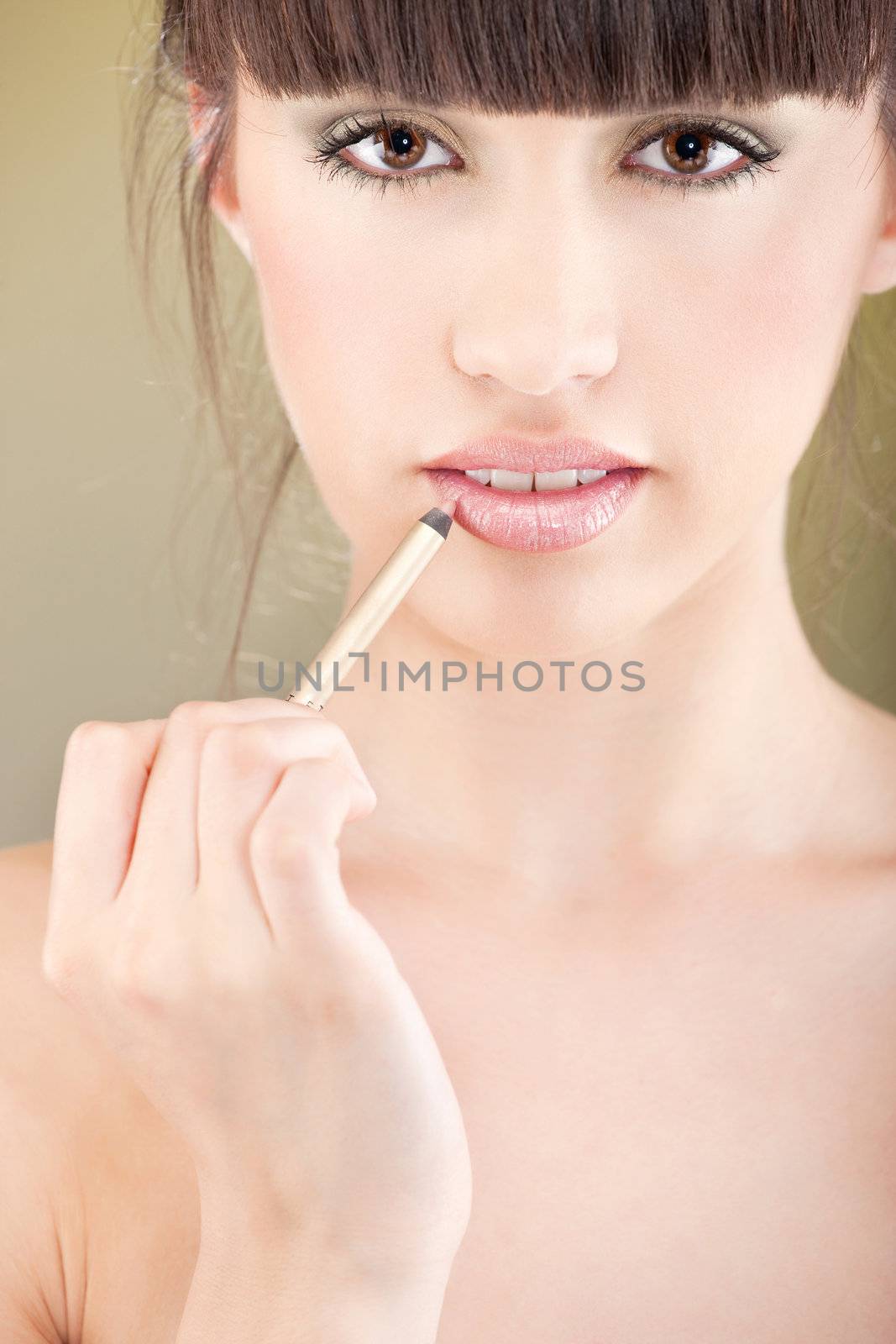 woman applying cosmetic pencil on lips