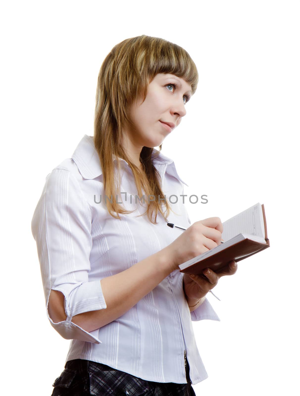 young girl in a white blouse writes in a notebook