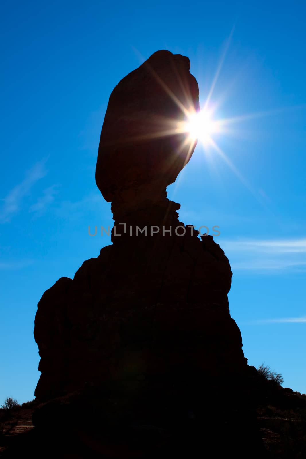 Sunlight shines from behind Balanced Rock at Arches National Park in Utah.