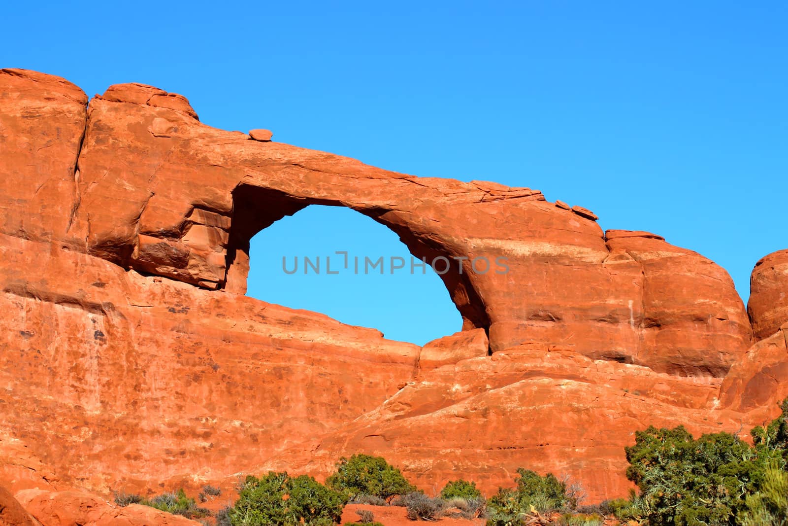 Skyline Arch stretches over a rocky landscape at Arches National Park of Utah.