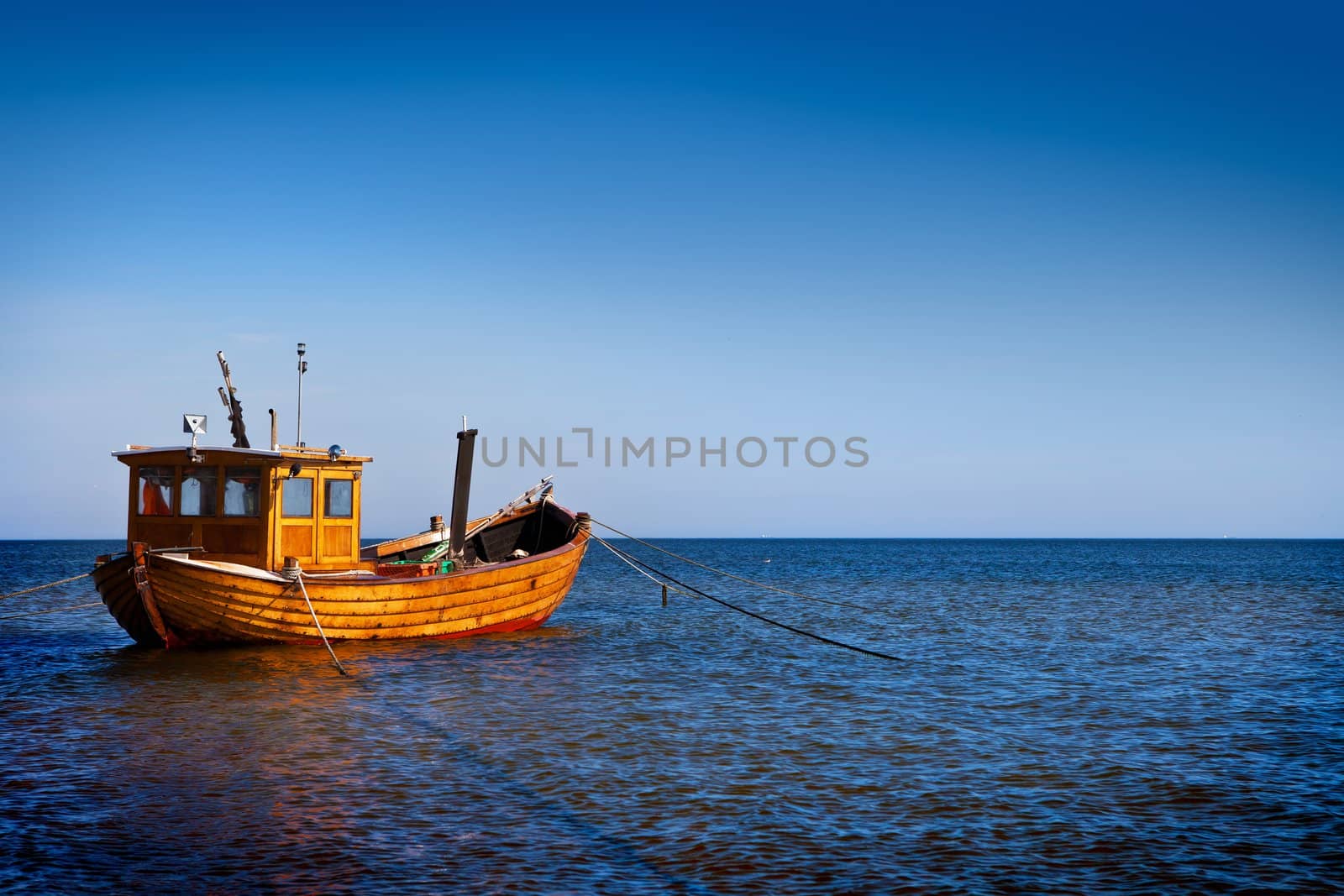 Fishing boat floating on the water, blue sea and sky with copyspace