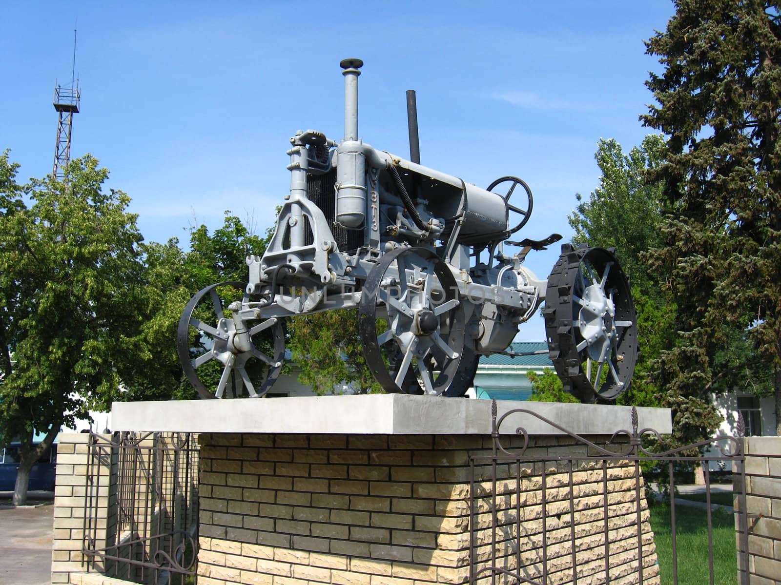 The ancient retro tractor standing on a pedestal