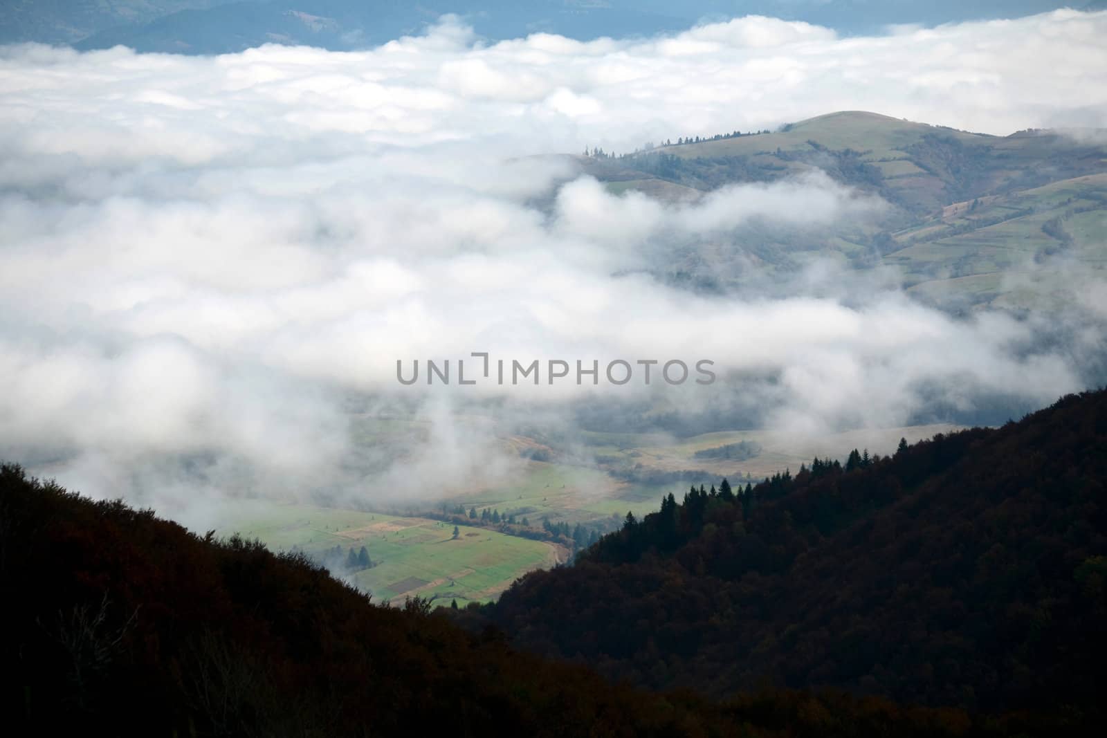 An image of white clouds in the mountains