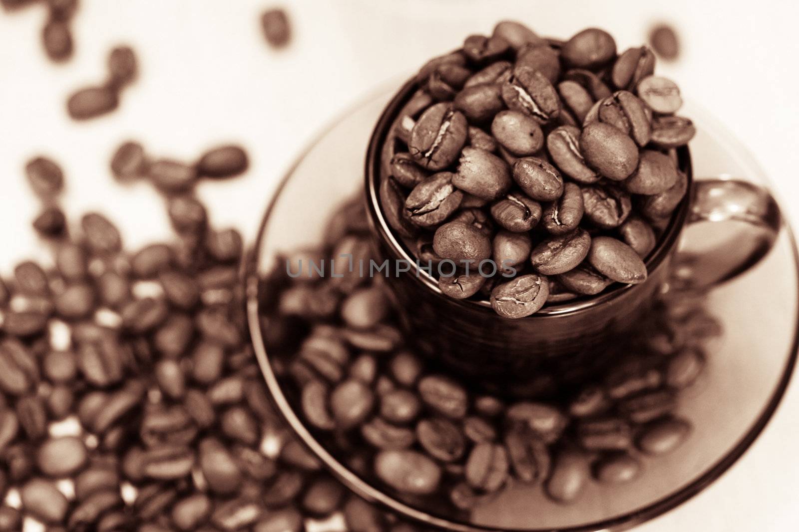 An image if coffee cup and spilled coffee beans closeup