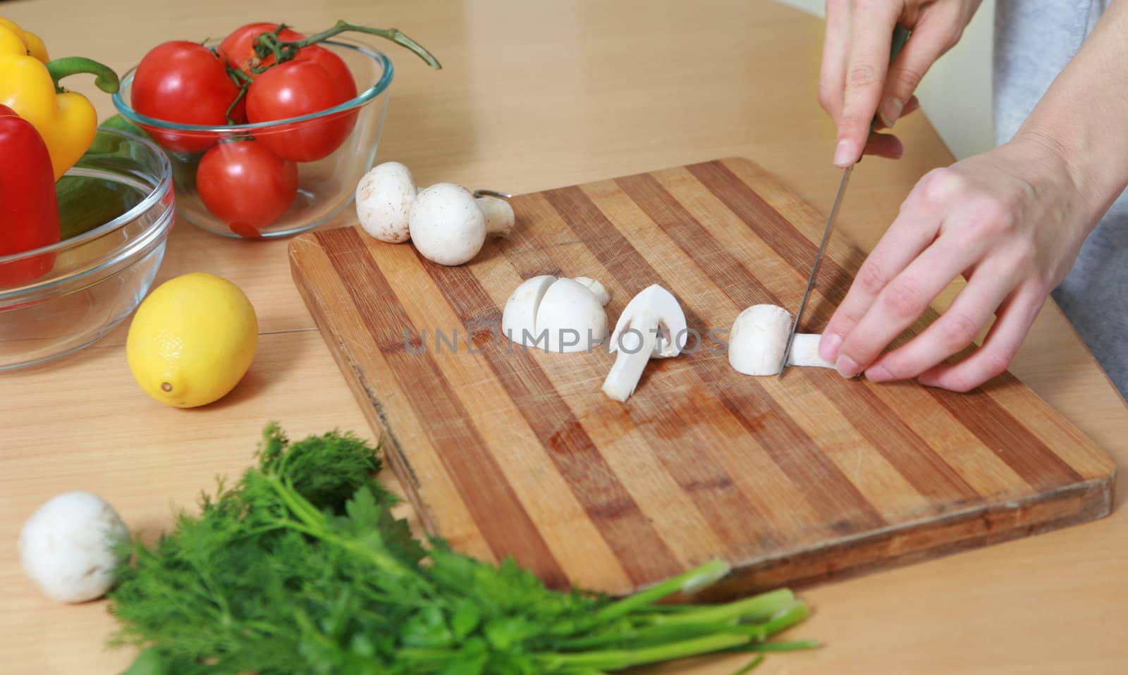 An image of hands cutting mushrooms