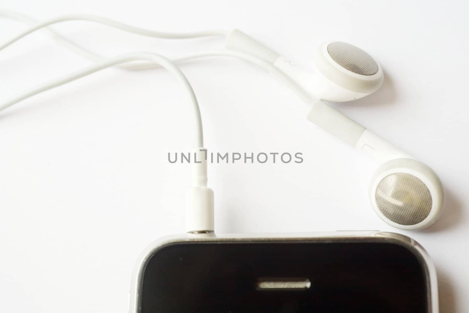 An image of little white headphones and mobile phone