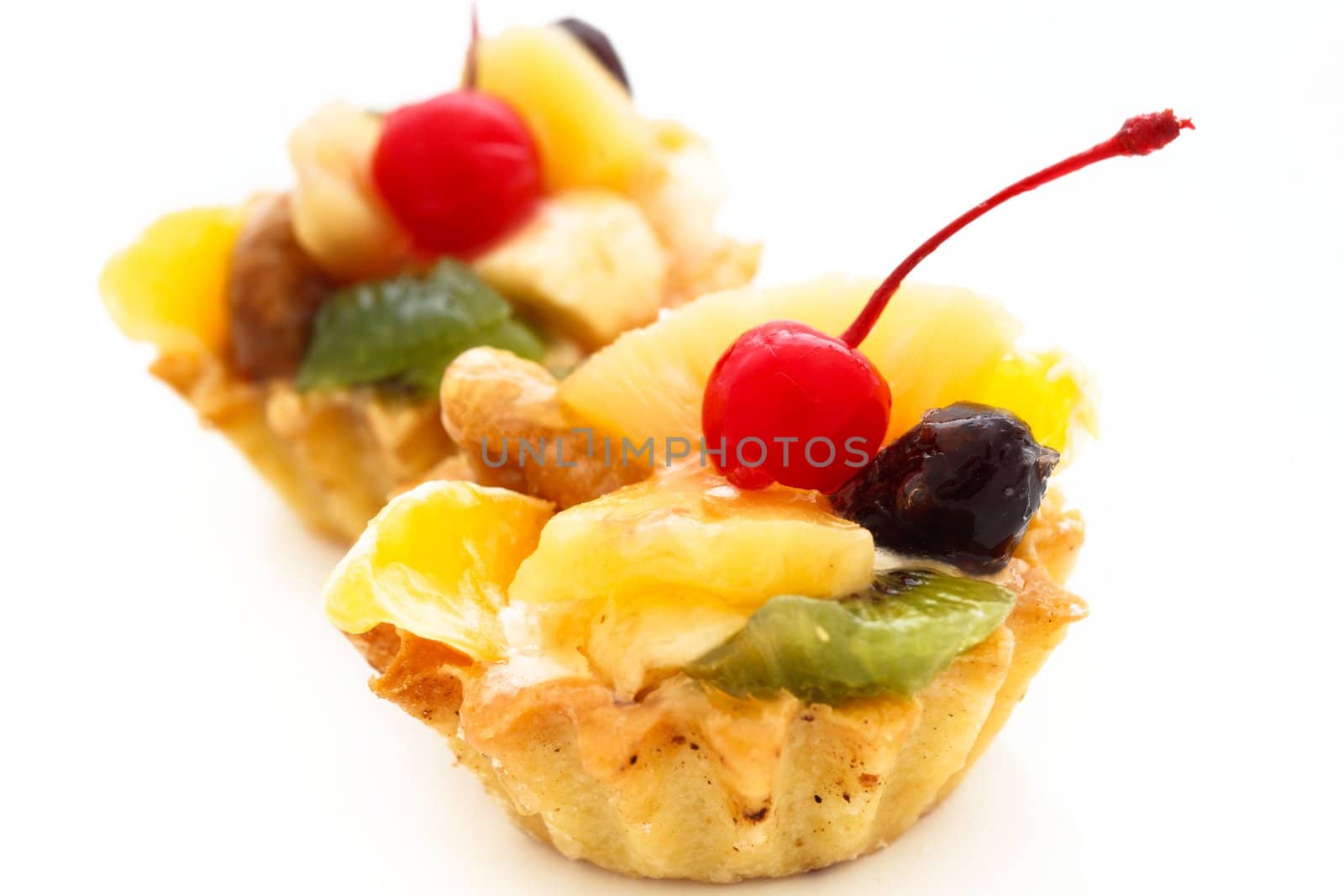 An image of two cakes with cherry on top. On white background.