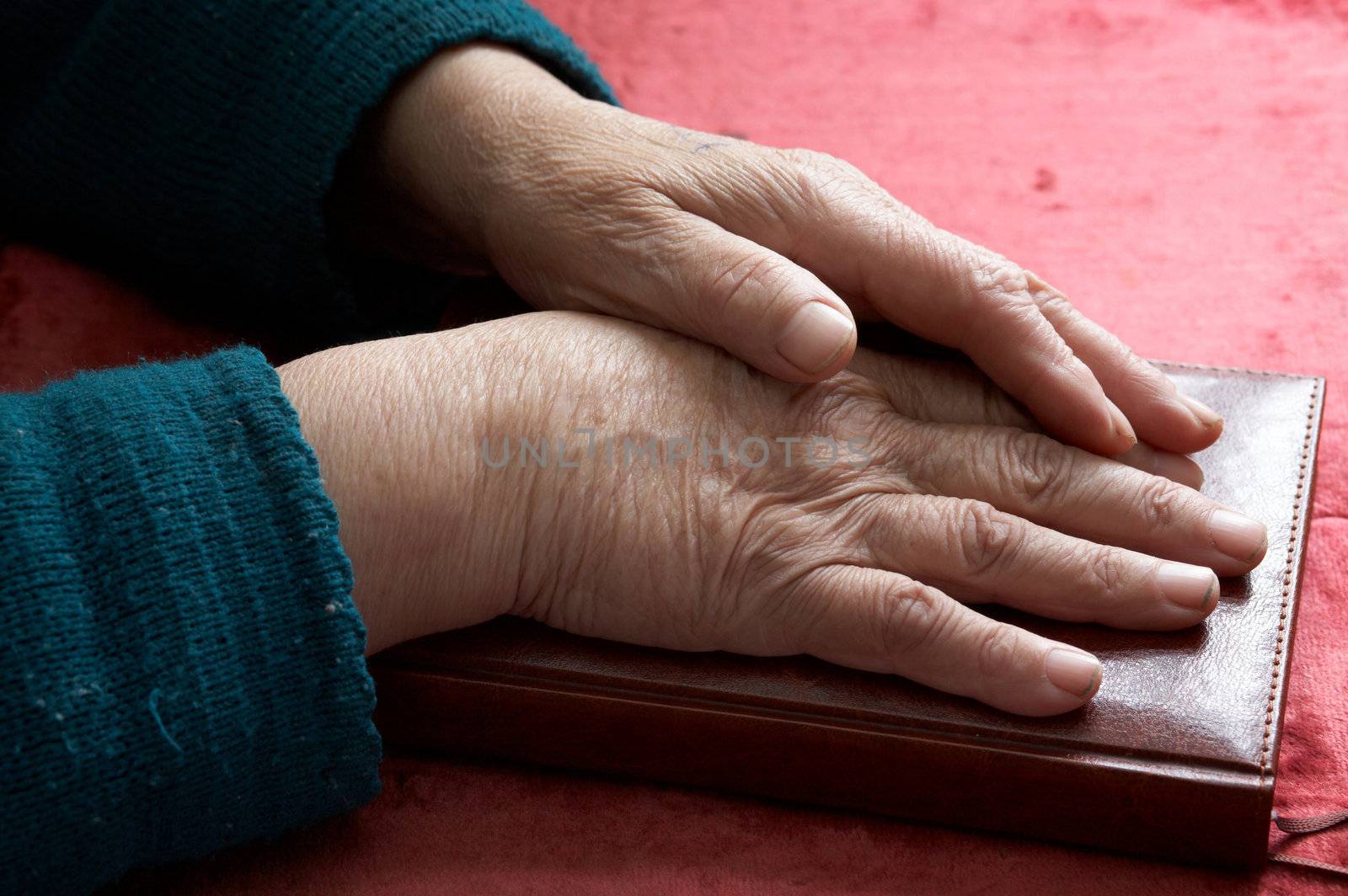 Stock photo: an image of old hands on a notebook