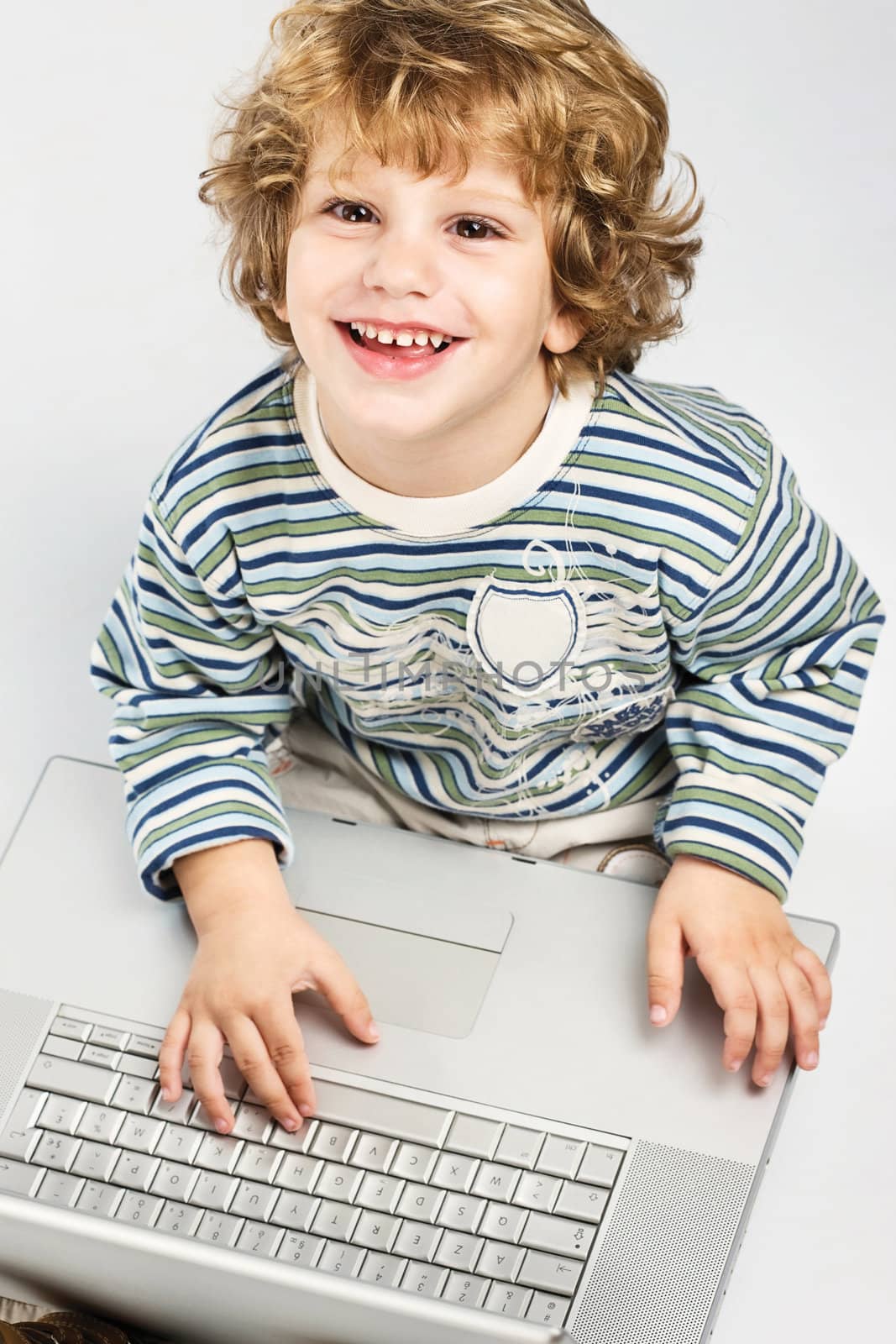 Happy blue curl hair boy holding laptop and smiling