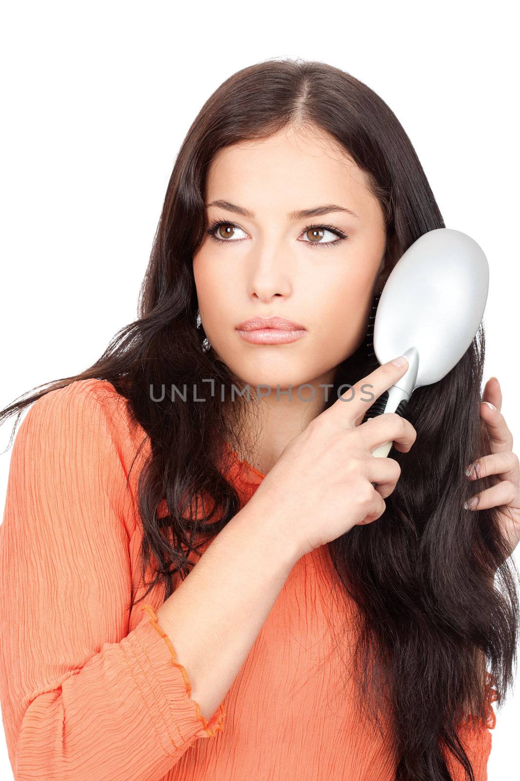 Portrait of a pretty woman combing her long black hair, isolated on white background