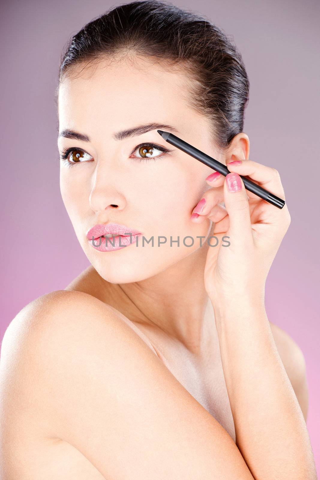 woman applying cosmetic pencil on eye by imarin