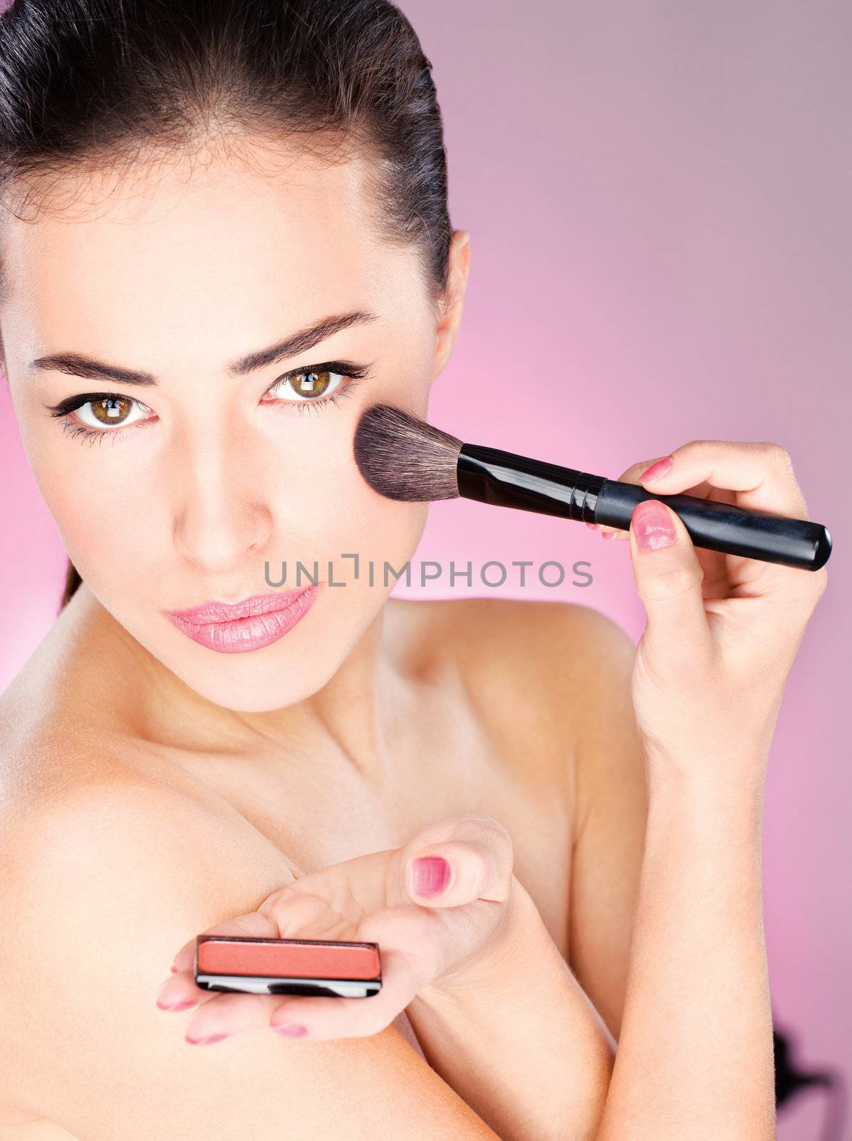 pretty woman applying cosmetic powder brush