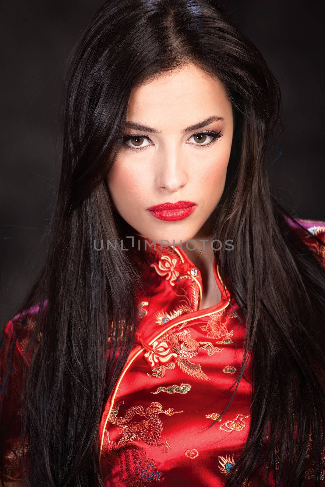 pretty woman in red Cheongsam on dark background