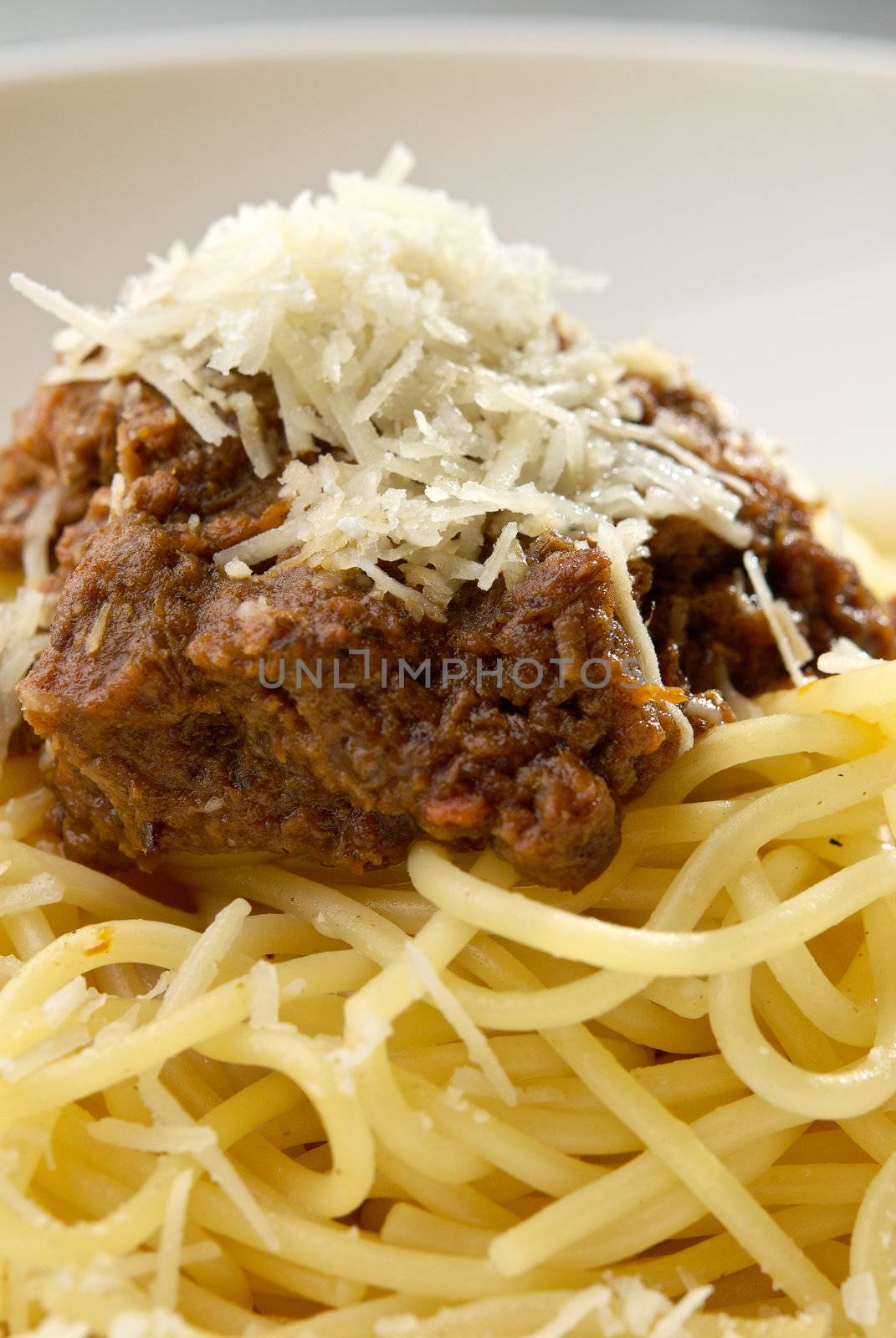 Spaghetti pasta with meat and cheese on the table in restaurant. Macro